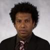 portrait of Kobi Abayomi in front of textured gray wall